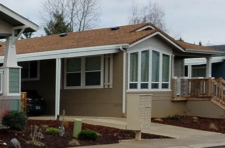 Manufactured home with a big bay window. The home is located in in a manufactured home community in Oregon.