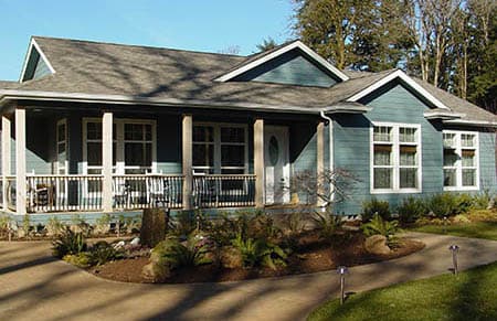 New Blue manufactured home on land with trees and nice landscaping in Oregon