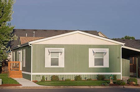 manufactured home with carport and staircase.